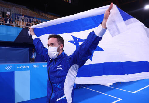El gimnasta israelí Artem Dolgopyat levanta la bandera nacional. 