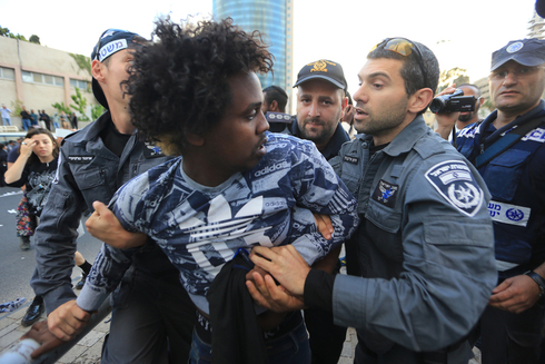 Policías israelíes detienen a un israelí descendiente de etíopes en una marcha en 2015.  