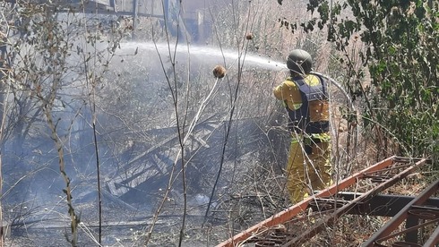 Un bombero lucha contra las llamas provocadas por el impacto de un cohete cerca de Kiryat Shmona.