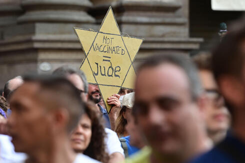 Otro manifestante anti-pase de salud en París sosteniendo una estrella de David amarilla. 
