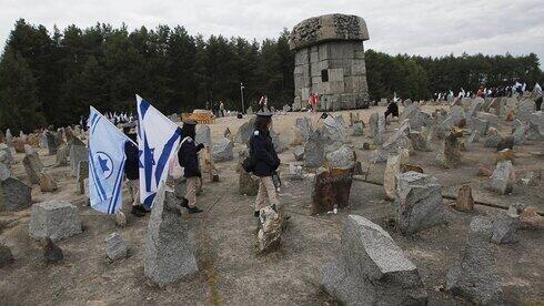 Jóvenes israelíes con sus banderas nacionales marchan junto al monumento a unos 900.000 judíos europeos asesinados por los nazis entre 1941 y 1944 en el campo de trabajo y muerte de Treblinka, en Polonia.