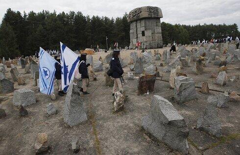 Jóvenes israelíes con sus banderas nacionales marchan junto al monumento a unos 900.000 judíos europeos asesinados por los nazis entre 1941 y 1944 en el campo de trabajo y muerte de Treblinka, en Polonia.