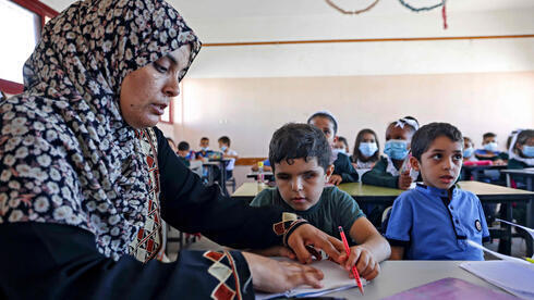 Mohammed Shaban recibe ayuda de su madre Somaya durante la clase en Beit Lahia, en el norte de la Franja de Gaza. 