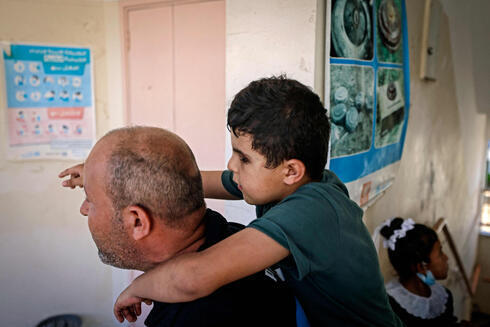 El padre de Mohammed lleva a su hijo a la escuela, este 17 de agosto. 