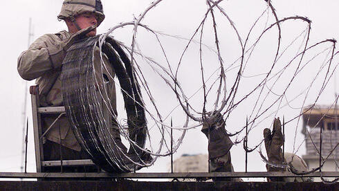 Un infante de marina estadounidense utiliza alambre de púas para proteger la embajada norteamericana en Kabul la semana pasada, mientras las fuerzas talibanes avanzaban hacia la ciudad. (AFP) Un infante de marina estadounidense utiliza alambre de púas para proteger la embajada norteamericana en Kabul la semana pasada, mientras las fuerzas talibanes avanzaban hacia la ciudad.