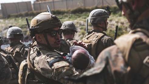 Un soldado estadounidense con un bebé afgano en sus brazos antes de ser evacuado de Afganistán el sábado.