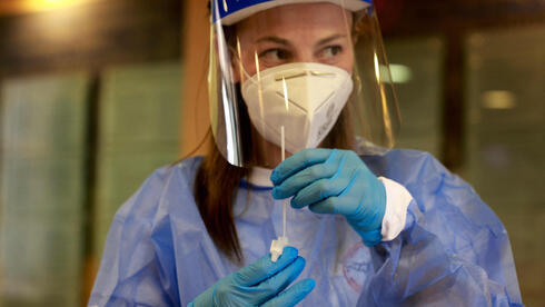 Una trabajadora de la salud sostiene una prueba de coronavirus en Jerusalem.