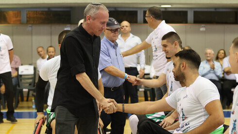 El ministro de Deportes y Cultura, Chili Tropper, saluda a los jugadores tras las finales de baloncesto.
