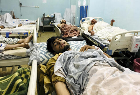 Afganos heridos yacen en una cama en un hospital después de una explosión mortal fuera del aeropuerto de Kabul. 