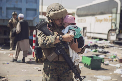 Una combatiente estadounidense con un bebé afgano en Kabul.