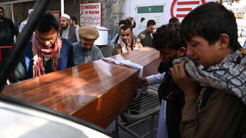 Afganos trasladan el ataúd de una víctima del atentado en Kabul.