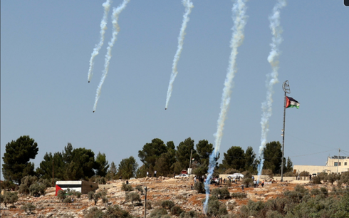 Las fuerzas israelíes disparan gas lacrimógeno mientras los palestinos en Beita se amotinan contra el puesto de avanzada.