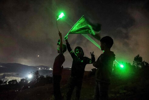 Alborotadores palestinos en Beita utilizan punteros láser durante una manifestación contra el puesto de avanzada de colonos israelíes de Eviatar. 