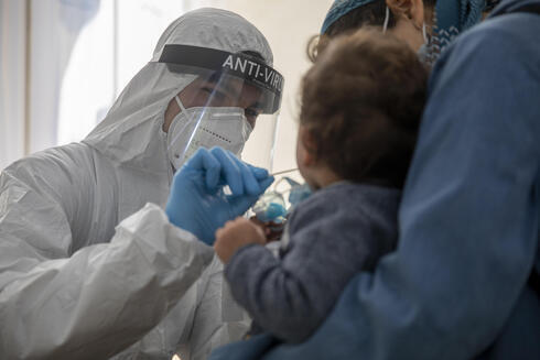 Personal de salud practica una prueba de coronavirus a un niño en Jerusalem. 