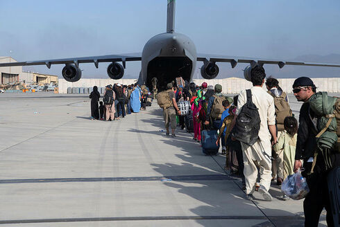 Afganos abordan un avión estadounidense para salir del país tras la toma del poder por parte de los talibanes.