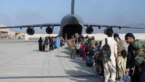 Afganos abordan un avión estadounidense para salir del país tras la toma del poder por parte de los talibanes.