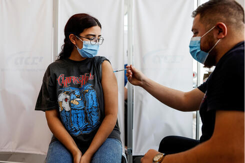 Una joven recibe una dosis de refuerzo contra el coronavirus en una clínica de Tel Aviv, 