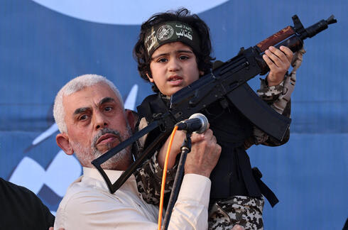 El líder de Hamas, Yahya Sinwar, sostiene al hijo de un combatiente de las Brigadas Al-Qassam, que murió en los recientes enfrentamientos con Israel. 