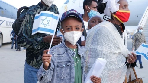 Un inmigrante etíope con la bandera israelí tras aterrizar en el Aeropuerto Ben-Gurion. 