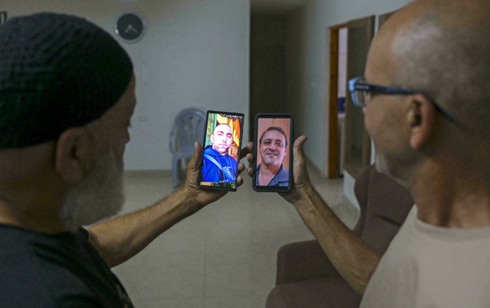 Malek Hassuna, a la izquierda, sostiene su teléfono con una foto de su difunto hijo Mussa, y Effi Yehoshua muestra una foto de su difunto hermano Yigal. 