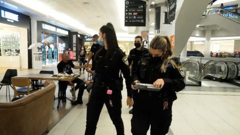La policía hace cumplir el uso de máscaras en un centro comercial de Haifa. 