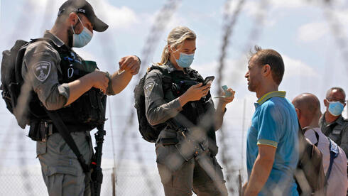 Fuerzas policiales interrogan a los trabajadores palestinos cerca del cruce fronterizo hacia el norte de Cisjordania. 