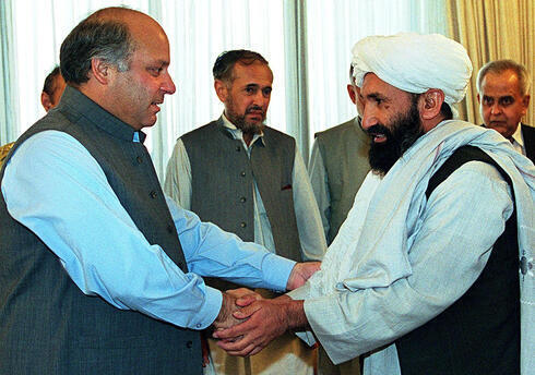 El entonces primer ministro pakistaní, Nawaz Sharif, recibe al entonces ministro de Relaciones Exteriores afgano mulá Mohammad Hassan Akhund (der.) en Islamabad en 1999. 