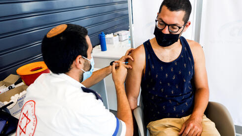 Un hombre recibe la vacuna COVID de refuerzo en Tel Aviv.