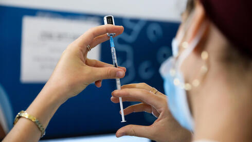 Una trabajadora de la salud se prepara para aplicar la dosis de refuerzo contra el COVID-19. 