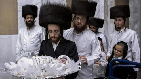 Tabersky lleva a su hijo de 30 días Yossef, el bisnieto del rabino principal de la dinastía jasídica Lelov, durante una ceremonia pidyon haben en Beit Shemesh, Israel.