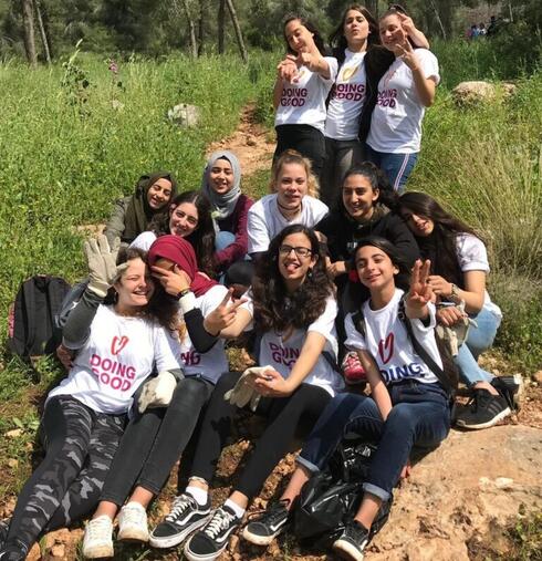 Niñas árabes y judías se ofrecieron juntas como voluntarias para limpiar los escombros de un bosque en el Día de las Buenas Acciones en Israel. 