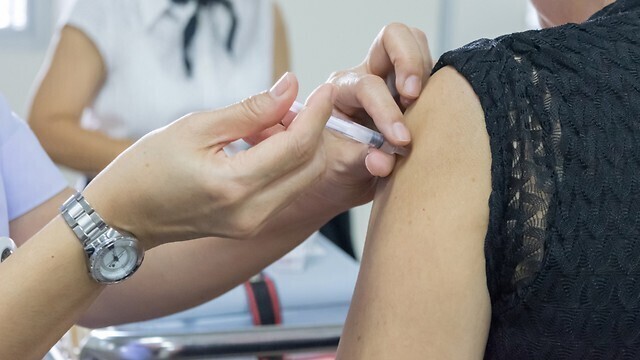 Una mujer recibe la vacuna contra la gripe. 