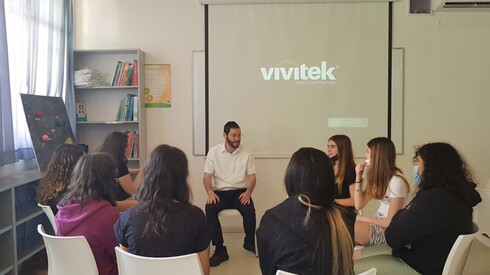 El voluntario Shlomo Goodman habla con chicas en una escuela secundaria de Hod Hasharon. 