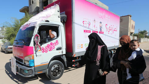 Mujeres palestinas pasan junto a una clínica móvil de control del cáncer de mama. (Reuters) Mujeres palestinas pasan junto a una clínica móvil de control del cáncer de mama.