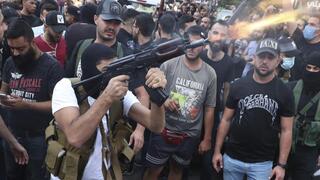 Partidarios del grupo chiíta Amal disparan armas al aire durante las procesiones fúnebres de Hassan Jamil Nehmeh, quien murió durante los enfrentamientos de ayer, en el suburbio de Dahiyeh, en el sur de Beirut, Líbano. 