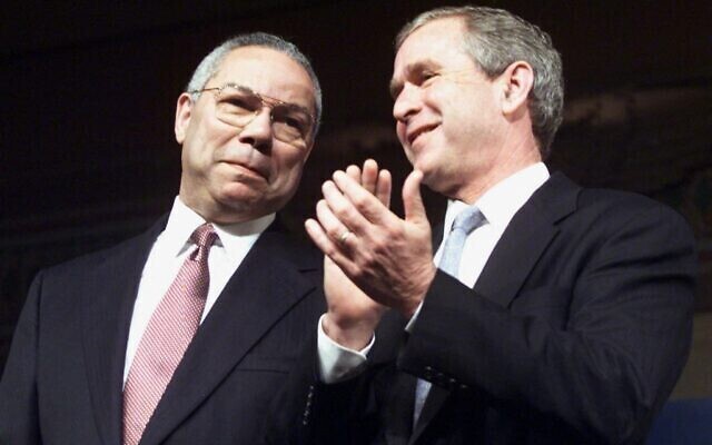George W. Bush y el general Colin Powell permanecen juntos en el escenario durante la campaña presidencial.