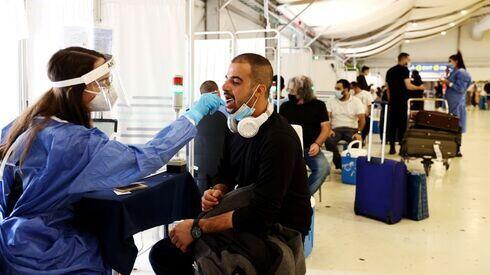 Aeropuerto Ben Gurión. Una trabajadora de la salud realiza un test PCR a un pasajero. 