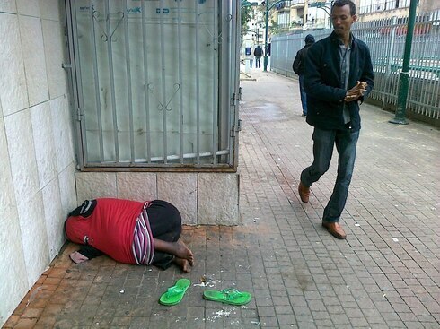 Un vagabundo duerme en el piso, fuera de la estación central de Tel Aviv. 