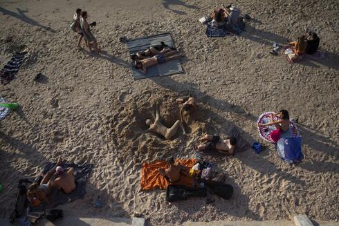Un hombre trabaja en una escultura de arena en Tel Aviv. 