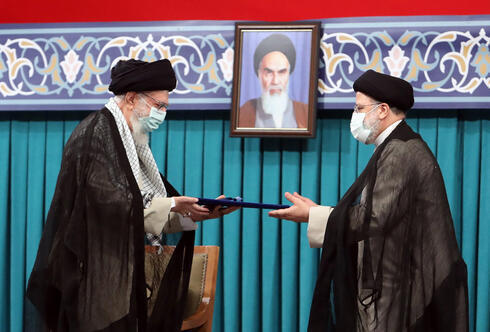 El líder supremo iraní, el ayatolá Ali Khamenei (izq.), entrega el precepto presidencial al presidente iraní Ebrahim Raisi (der.), en Teherán, Irán. 