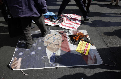 Manifestantes iraníes pisan una imagen del presidente estadounidense Joe Biden durante la manifestación para conmemorar los 42 años de la toma de la Embajada de Estados Unidos.