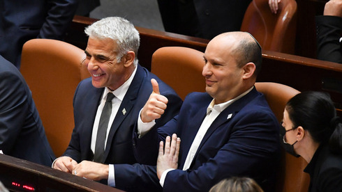 Yair Lapid y Naftalí Bennett, líderes de la coalición de gobierno, celebran la aprobación del presupuesto estatal para 2022. 