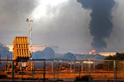 Batería de defensa antimisiles en primer plano y humo de fondo en una refinería de Ashkelon tras un ataque desde Gaza, el 12 de mayo de 2021. 