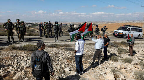 Manifestantes sostienen banderas palestinas durante una manifestación de protesta contra los asentamientos en Cisjordania. 