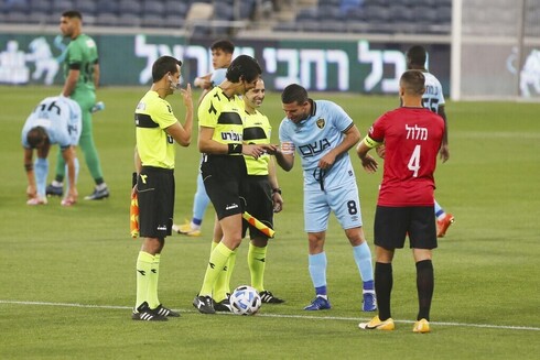 Idan Vered, capitán del Beitar Jerusalem, observa de cerca las manos de Sapir Berman, la primera árbitro transgénero del fútbol israelí.