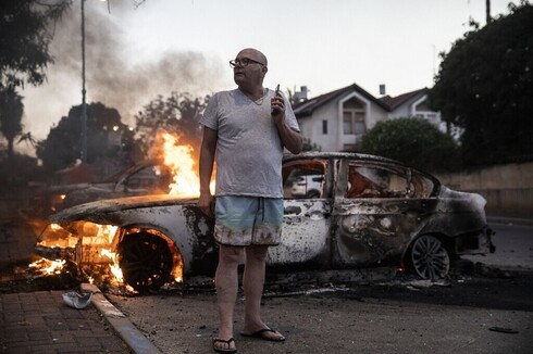 Jacob Simona al lado de su automóvil, que fue prendido fuego durante los disturbios de mayo en Lod.