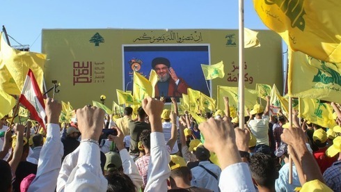 Partidarios de Hezbolá ondean la bandera del grupo durante una conmemoración que marca el 13º aniversario del final de la guerra de 2006 con Israel en el sur del Líbano. 
