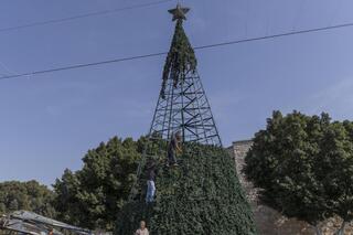 Trabajadores palestinos preparan un árbol de Navidad en la plaza adyacente a la Iglesia de la Natividad. 