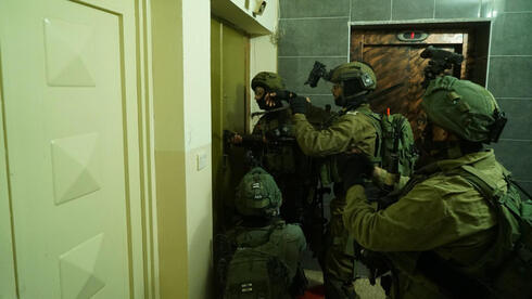 Las tropas de las FDI se preparan para irrumpir en un apartamento de Ramala en busca de sospechosos de terrorismo en 2018.