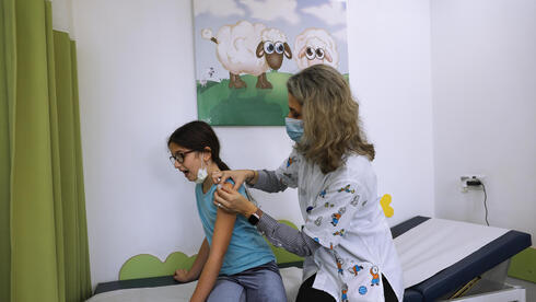 Una trabajadora de la salud administra una dosis de vacuna a una niña israelí en Tel Aviv. (AP) Una trabajadora de la salud administra una dosis de vacuna a una niña israelí en Tel Aviv.